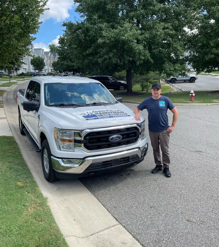 Vitaliy of Quick Fix LLC beside his branded Ford F-150 work truck in Williamsburg, VA