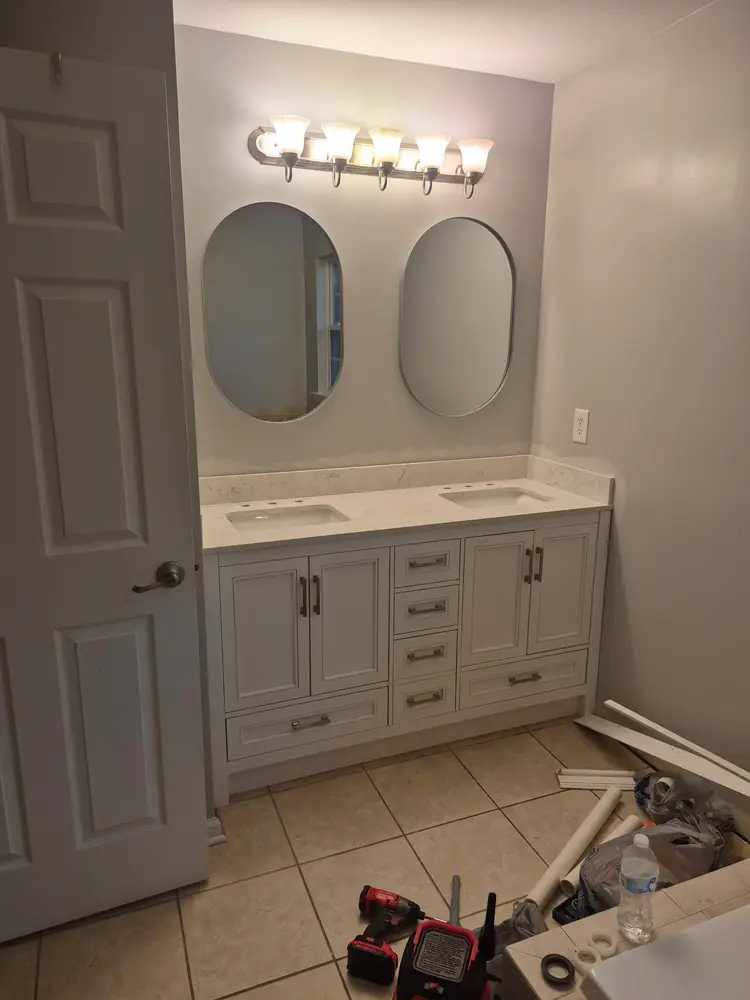 Finished double vanity with quartz top, oval mirrors and light bar