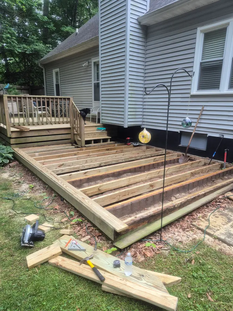 Old deck boards lifted, joists exposed and checked